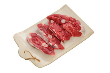 Lamb meat on a ceramic board isolated on white background. Pieces of meat for cooking. Rear part of the meat carcass.