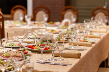 Served festive table with snacks, glasses, glasses, cutlery and napkins for a banquet