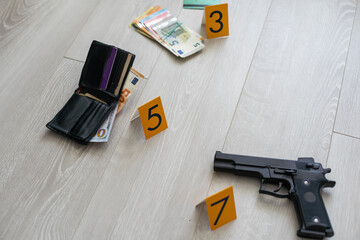 Crime scene investigation - numbering of evidences after the murdering in apartment. Brass knuckle, wallet and clothes with evidence markers