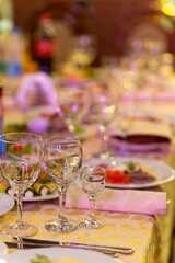 Served festive table with snacks, glasses, glasses, cutlery and napkins for a banquet