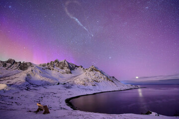 Norway, Troms og Finnmark, Starry night sky over empty bench overlooking Mefjord