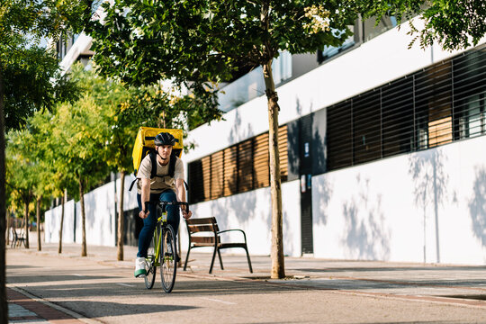 Delivery person with bag riding on bicycle