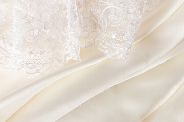 Chic luxury wedding background for design. soft pleats of creamy satin and part of lace tulle. The...