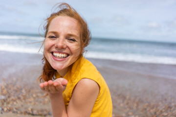 Cheerful woman gesturing at beach on summer holiday
