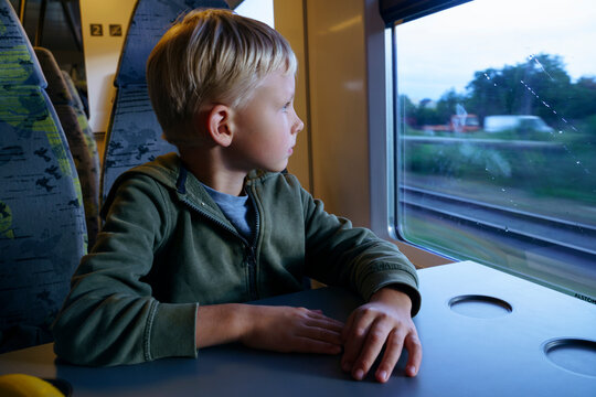 Thoughtful boy looking through train window
