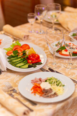 Served festive table with snacks, glasses, glasses, cutlery and napkins for a banquet