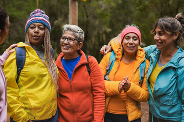 Group of multi generational women having fun during hiking day in the forest - Multiracial female...