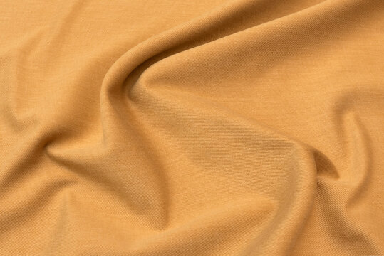 Abstract background texture of natural beige or brown colour fabric. Fabric texture of natural cotton or linen, silk or satin, wool or jersey textile material. Luxurious canvas background..