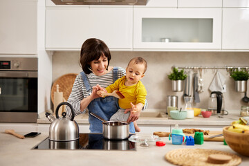 Mother and baby boy cooking in the kitchen
