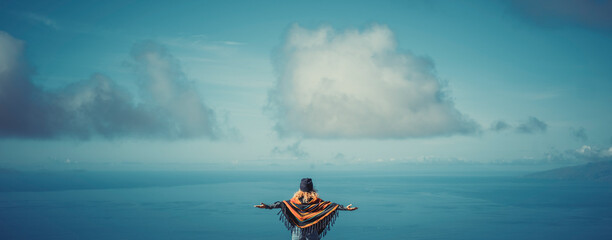 Woman relaxing with open arms in blue winter sky. People's freedom style..​