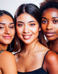 Pretty diverse young girls standing together smiling isolated on background. cheerful african and caucasian women models advertising skin care natural beauty