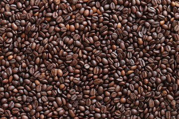 Top view of background representing halves of dark brown coffee beans. Roasted coffee beans, copy space