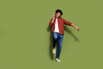 Full size photo of handsome young guy funky dancing have fun wear trendy brown outfit isolated on khaki color background