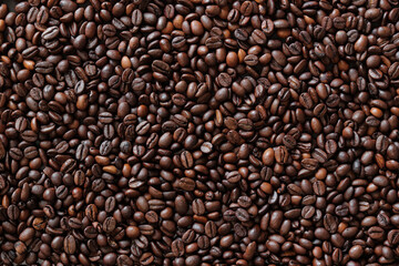 Top view of background representing halves of dark brown coffee beans. Roasted coffee beans, copy space