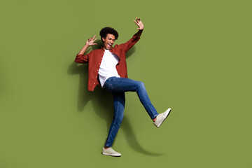 Full body photo of attractive young man happy energetic dancing wear trendy brown clothes isolated on khaki color background