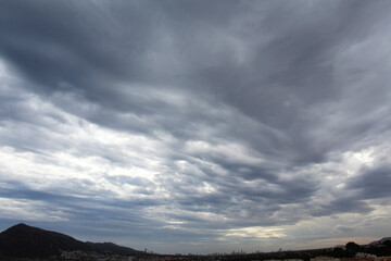 storm clouds over mountains and a city in Spain