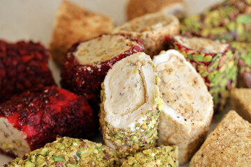 Many rolls of turkish delight with different flavors and fillings close up on table. Cutted Turk Lokumu bars