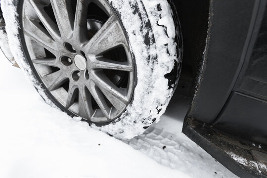 A car wheel on snow tire with metal studs. Close-up photo