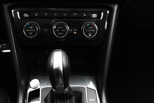 Gear lever and black climate control panel of a modern car. Close up