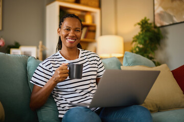 Happy african american woman with laptop at home