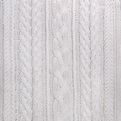 The texture of a white knitted sweater in close-up