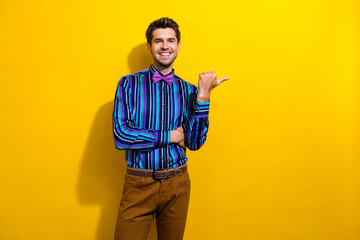 Photo of satisfied positive man dressed striped shirt indicating at proposition empty space...