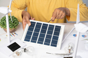 Businessman with solar panel in office.