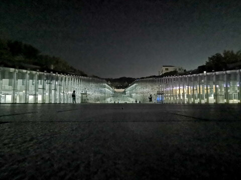 SEOUL, SOUTH KOREA - OCTOBER 27, 2022: Ewha Womans University main underground student lecture hall and library at dark night time landscape scene. There are student stand in the photo.