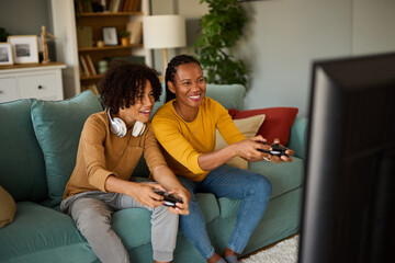 Mother and son playing video games at home