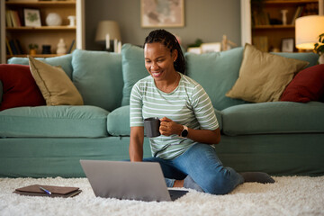 Happy african american woman with laptop at home