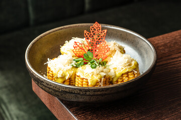 roasted sweet corn smeared with cheese in bowl. Restaurant menu, dieting, cookbook recipe top view