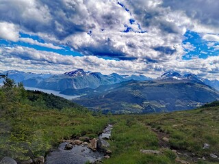 Fototapeta na wymiar Epic cloudscape over mountain peaks and fjord