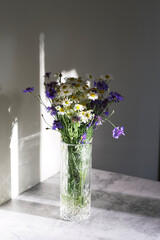 bouquet of wild summer flowers. cornflowers and daisies in a vase. white and purple flowers