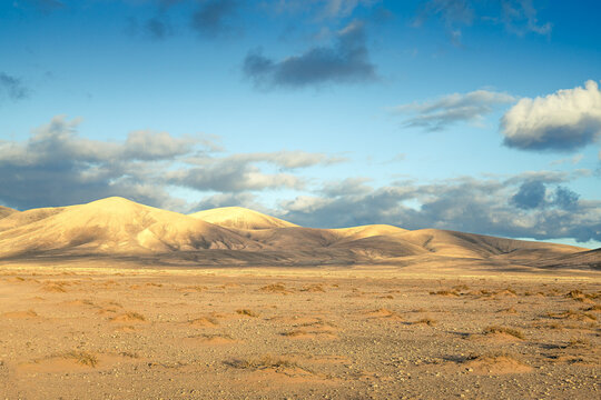 Sandberge und W&uuml;stenlandschaft mit Himmel und kleineren Wolken am Tag auf Fuerteventura