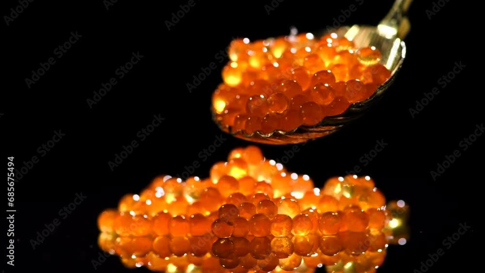 Wall mural Red Caviar in a spoon over black background. Close-up of salmon fish roe caviar. Delicatessen. Texture of trout caviar. Backdrop. Seafood 