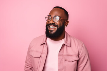 Obraz premium Portrait of a happy young african american man with glasses against pink background
