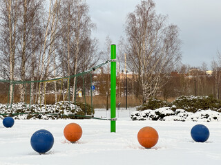 A playground in a park covered in thick layer of pristine white snow. Play attributes standing...