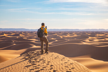 An adventurer stands on a dune, gazing at the endless horizon, embodying the spirit of exploration...