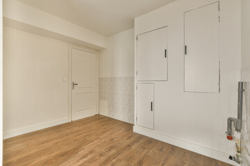 an empty room with white cabinets and a wood floor