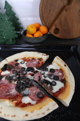 Pizza with sausage on the table in the kitchen