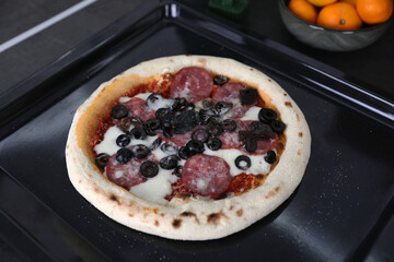 Pizza with sausage on the table in the kitchen
