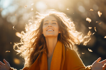 Joyful woman with arms outstretched in sunlight. Captures concept of freedom and happiness.