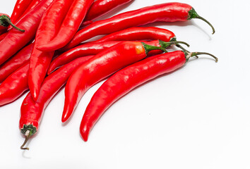 Close up of bunch of long red chili peppers on a white background isolated. It lies diagonally.