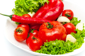 Delicious vegetable salad in bowl with water drops. Tomatoes, lettuce, garlic, chili, sweet pepper.
