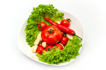 Delicious vegetable salad in a bowl with water drops. Tomatoes, lettuce, garlic, chili.