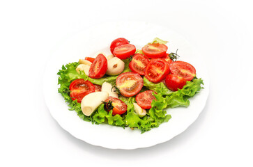 Delicious vegetable salad in a bowl on a white background. Chopped tomatoes, lettuce, garlic, salt.