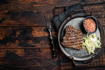 Deer venison steak with   sea salt and salad. Wooden background. Top view. Copy space