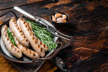 Sausages fried with spices and herbs, meat Bratwurst. Wooden background. Top view. Copy space - obrazy, fototapety, plakaty