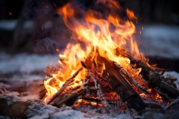 Poster Lagerfeuer bei Nacht im Schnee im Wald. Holz brennt mit heißen Flammen in schneebedeckter Landschaft. Outdoor Campingplatz auf der Lichtung im Winter. © Marco