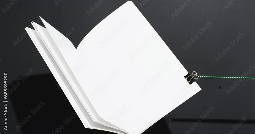Aufkleber video of book with string and white blank pages and copy space on black background